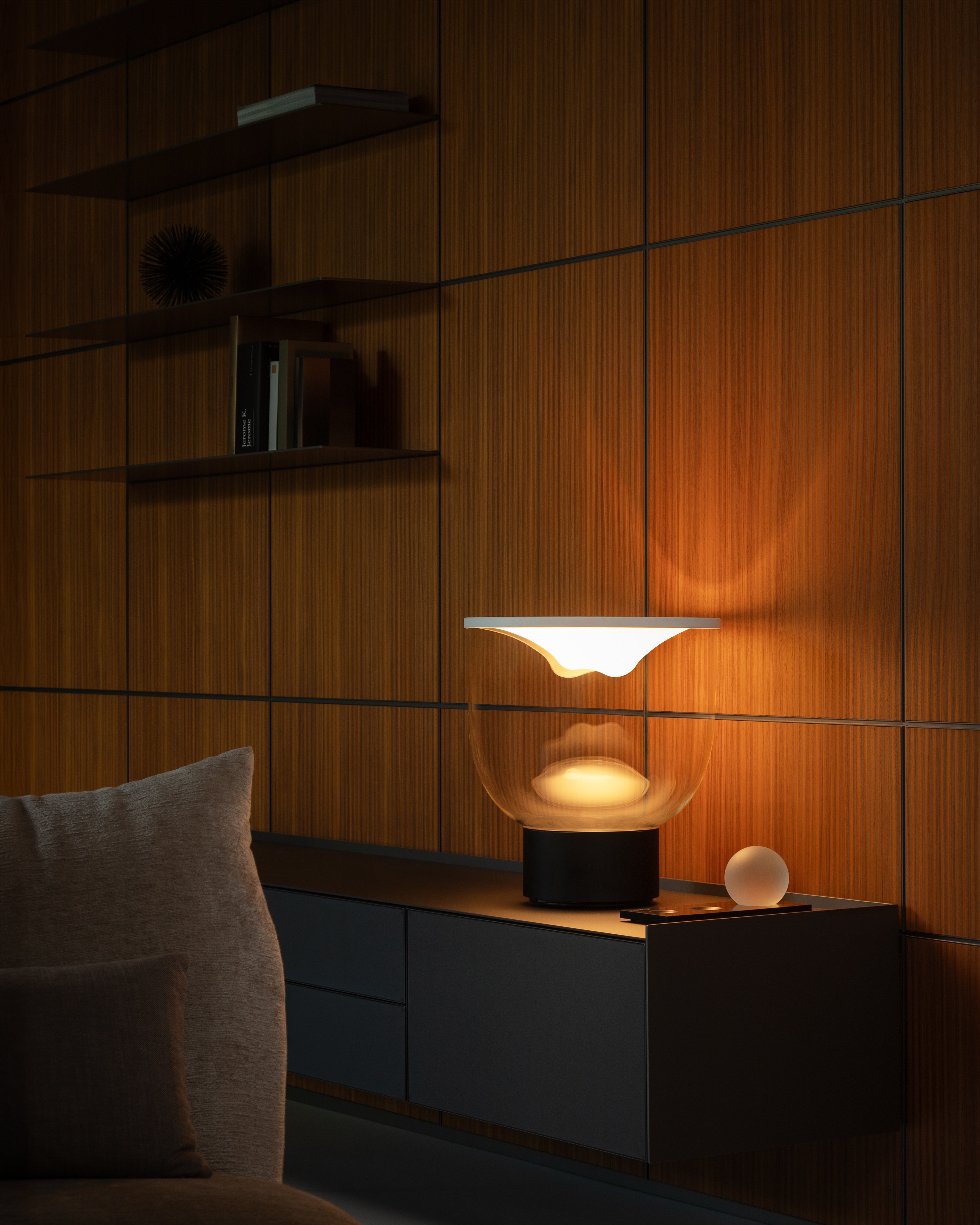 Stolní lampa GRAMMOLUCE se skleněným stínidlem a černým podstavcem.
