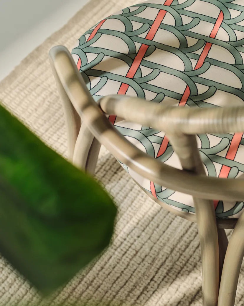 Čalouněné křeslo BISTRA s olivovým ratanovým podstavcem