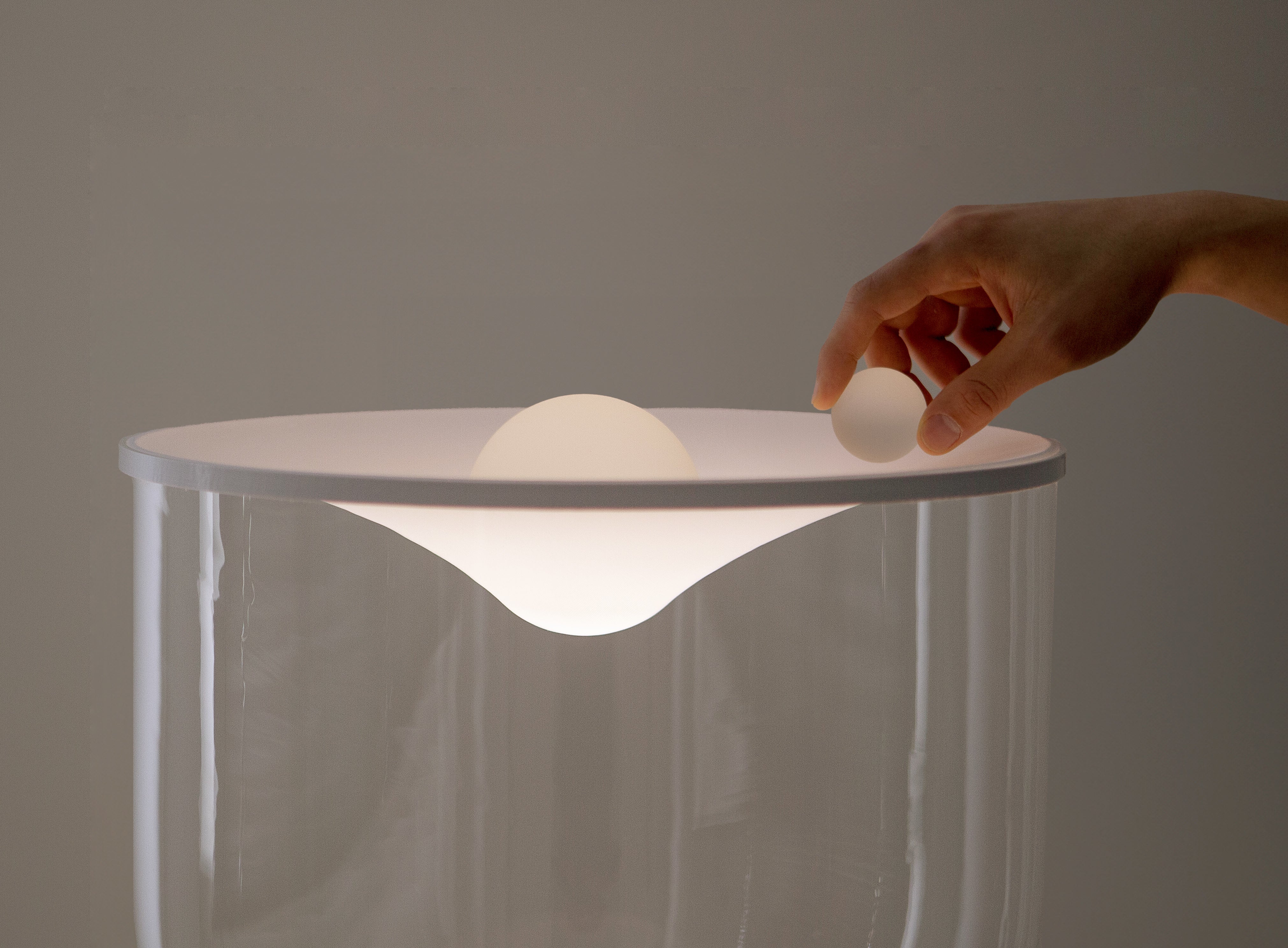 Stolní lampa GRAMMOLUCE se skleněným stínidlem a černým podstavcem.