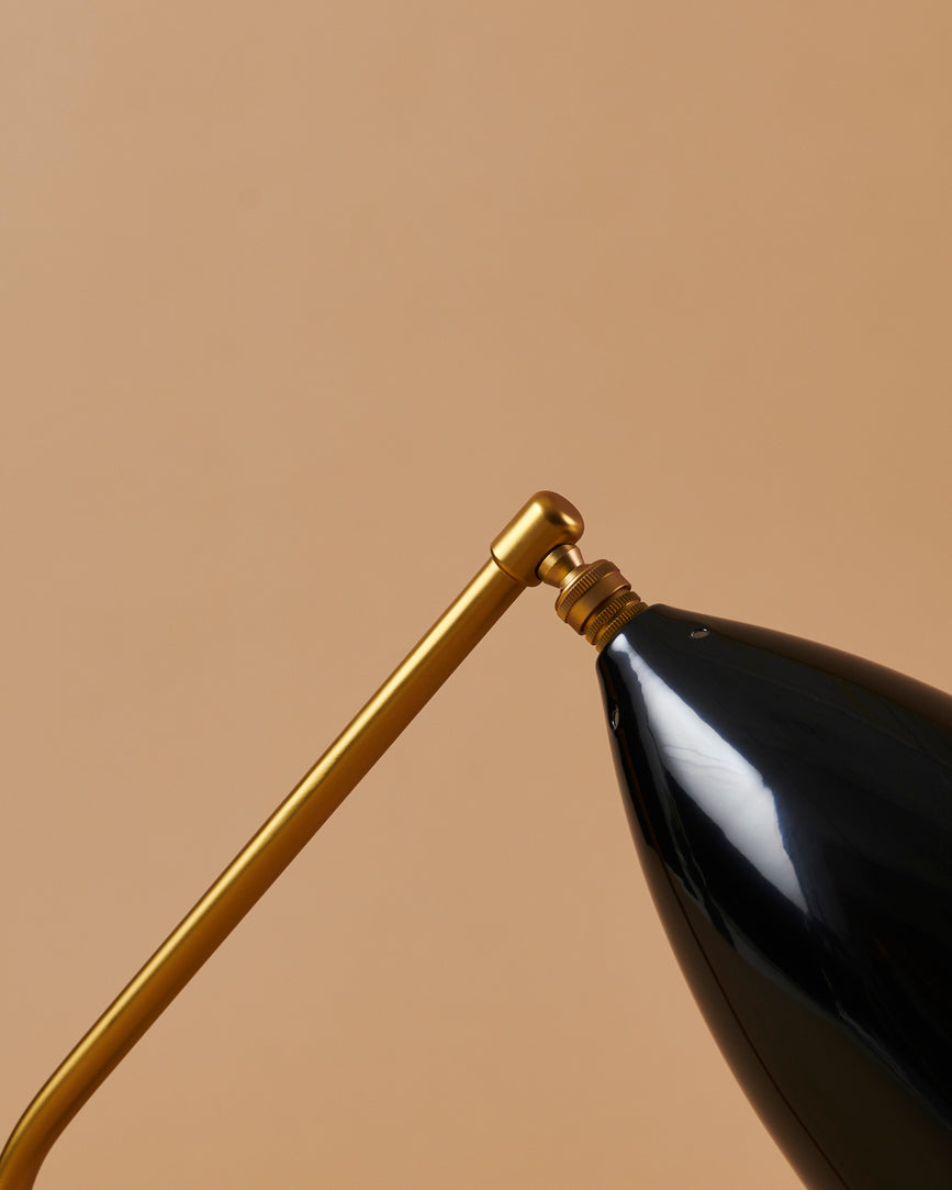 GRÄSHOPPA table lamp with a black glossy shade and a gold base