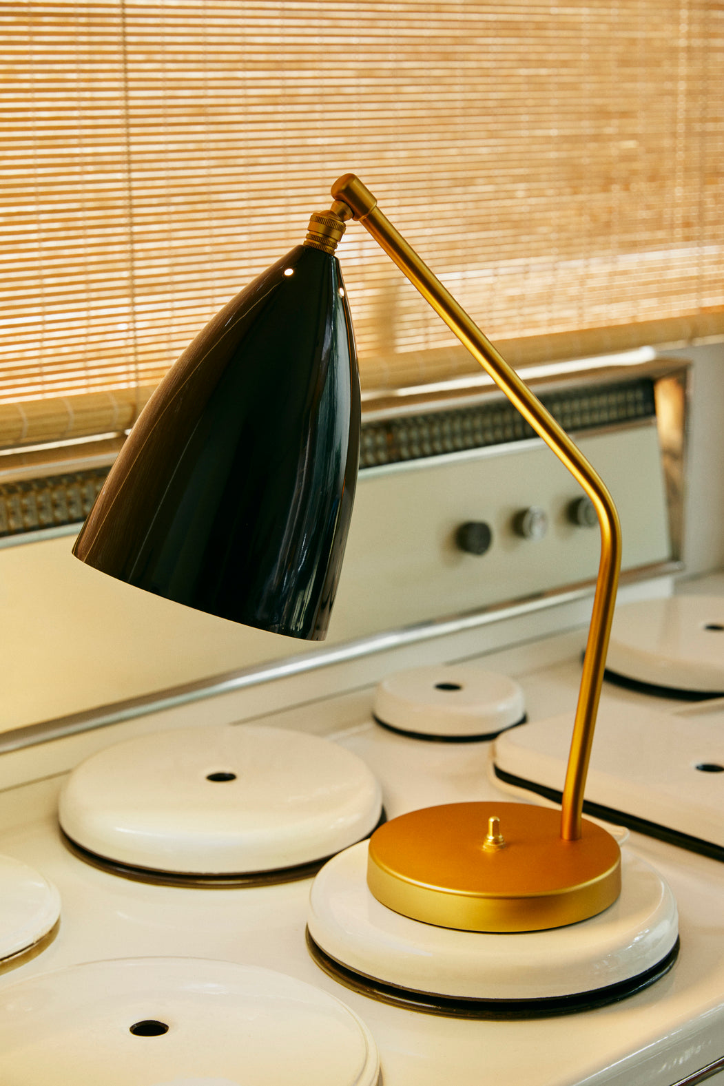 GRÄSHOPPA table lamp with a black glossy shade and a gold base