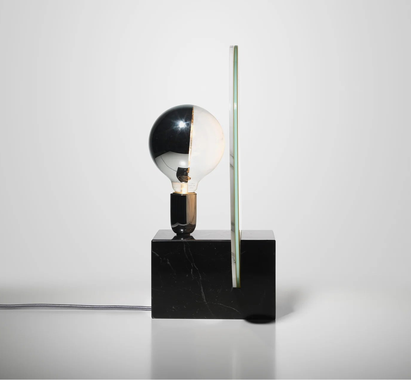 Stolní lampa ACID MARBLE v kyselě žluté barvě s černým mramorovým podstavcem.