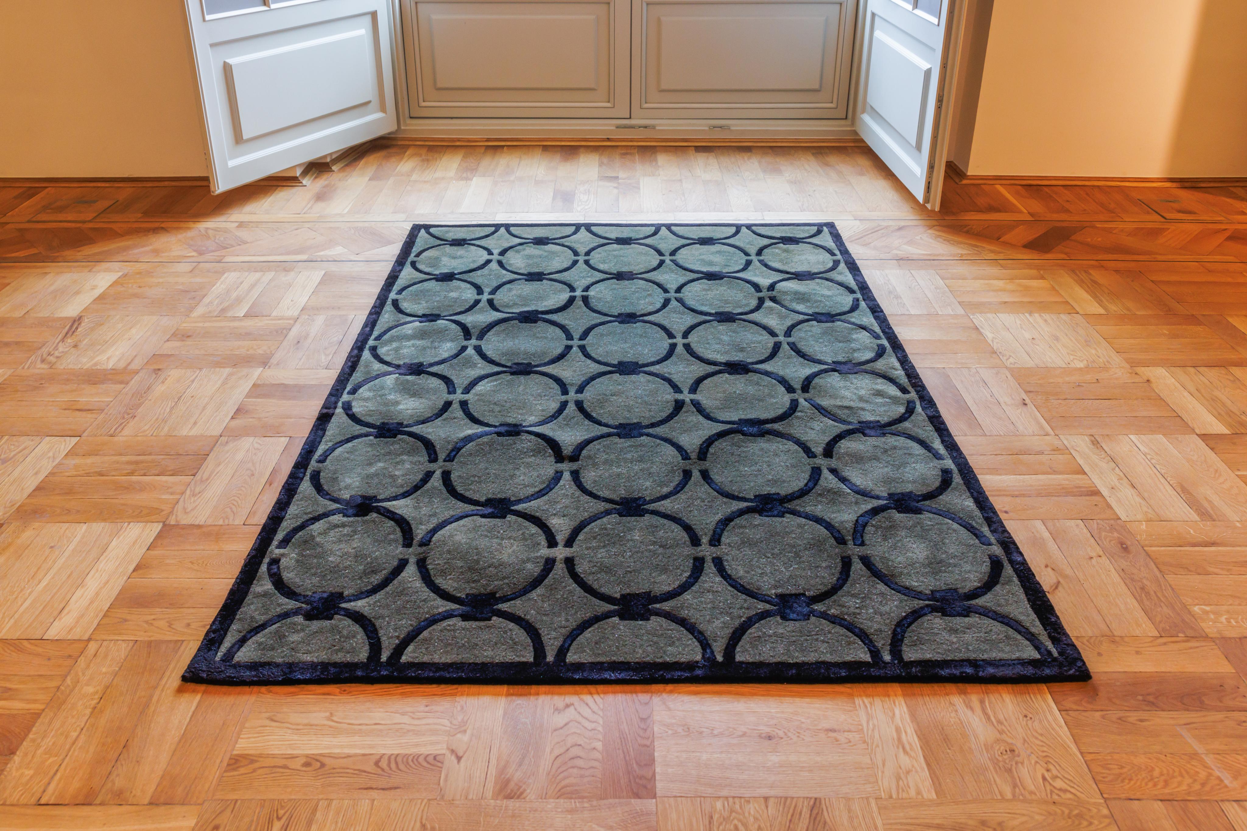 GLAM dark green rug with black geometric pattern