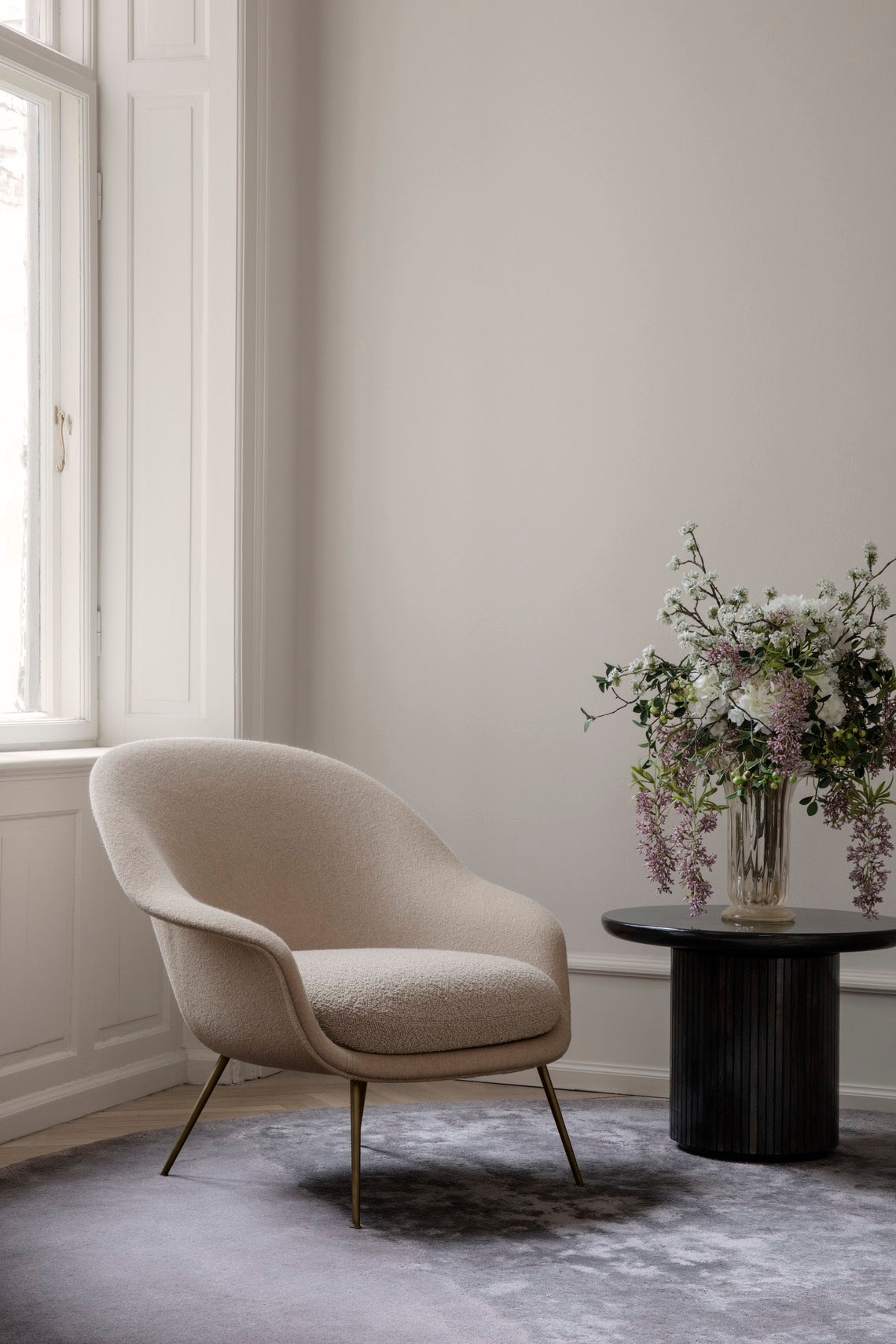 Upholstered BAT armchair with a gold base