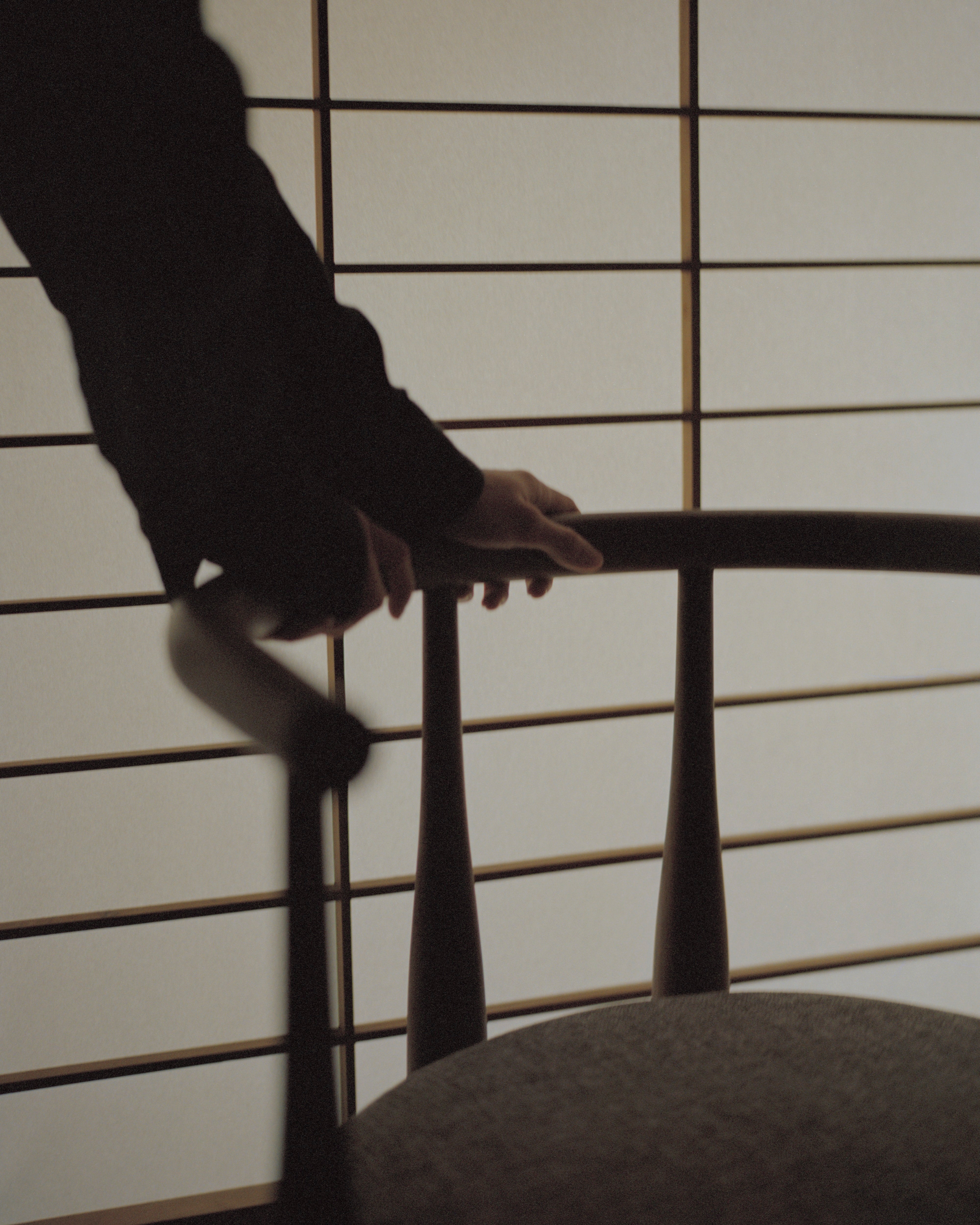 Čalouněné křeslo BUKOWSKI s ořechovým podstavcem